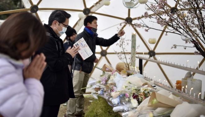 KMA101 TOKIO (JAPÓN) 11/03/2016.- Varias personas rezan durante un evento celebrado en memoria de las víctimas del terremoto y posterior tsunami de hace cinco años en Tokio (Japón) hoy, 11 de marzo de 2016. Japón recordó hoy con un minuto de silencio el terremoto y el tsunami acaecidos hace justo cinco años, que dejaron más de 18.000 muertos y desaparecidos en el noreste de Japón y provocaron el accidente nuclear de la central de Fukushima. En los diversos actos celebrados por todo el país se guardó un minuto de silencio a las 14.46 hora local (05.46 GMT), momento exacto en el que el 11 de marzo de 2011 se registró el terremoto de 9 grados en la escala abierta de Richter que desencadenó la tragedia. EFE/Franck Robichon